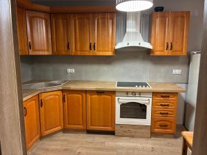 a kitchen with wooden cabinets and a white stove top oven at Chata Smarzewo in Smętowo