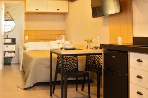 a kitchen with a table with two chairs and a bed at Eco Green Container- Guarda do Embaú SC in Palhoça
