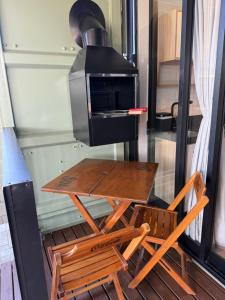 a table and two chairs in front of a stove at Eco Green Container- Guarda do Embaú SC in Palhoça