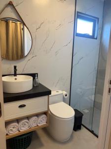 a bathroom with a toilet and a sink and a shower at Eco Green Container- Guarda do Embaú SC in Palhoça +12 photos