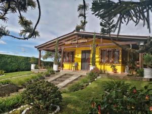 a yellow house with a garden in front of it at Villa Luz Hotel in Silvia