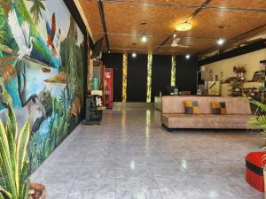a lobby with a couch and a large painting on the wall at Libélula Hotel in Puerto Maldonado