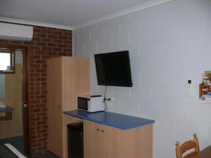a room with a counter with a microwave and a tv at Milawa Motel in Milawa