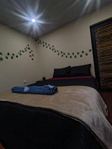 a bedroom with a bed with a blue jeans on it at Cabañas el guadual in La Vega