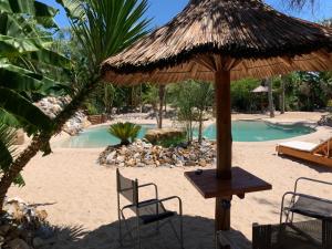 a table and chairs under a straw umbrella on the beach at Espacio Natural in Gualeguaychú