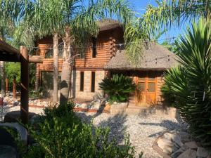 a log house with a thatched roof at Espacio Natural in Gualeguaychú