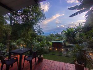 a patio with a table and chairs on a deck at Cabañas el guadual in La Vega