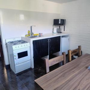 a kitchen with a white stove and a sink at Departamento 8 in El Bolsón