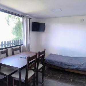 a room with a table and a bed and a window at Departamento 8 in El Bolsón