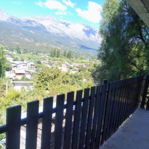 a wooden fence with mountains in the background at Departamento 8 in El Bolsón