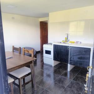 a kitchen with a table and a sink and a stove at Departamento 8 in El Bolsón +5 photos