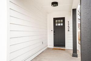 a black door on a white house at Indy Getaway - Near Downtown Indy - Sleeps 10! in Indianapolis +40 photos