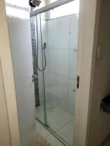 a shower with a glass door in a bathroom at Casa ampla e confortável in Corumbá +52 photos