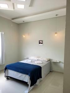 a bedroom with a bed with a blue blanket on it at Casa ampla e confortável in Corumbá