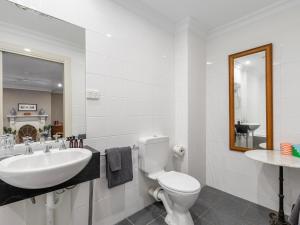 a bathroom with a sink and a toilet and a mirror at Athelstane Hotel in Queenscliff +37 photos