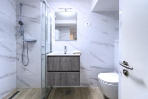 a bathroom with a sink and a toilet and a shower at The LOFT Ljubljana in Ljubljana