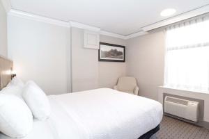 a bedroom with a white bed and a chair at Sandman Signature Vancouver Downtown Hotel in Vancouver +49 photos