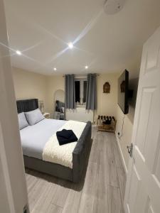 a bedroom with a bed and a room with a door at New 2-bed 2-bath detached flat with garden in Enfield