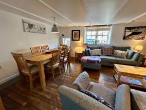 a living room with a couch and a table at 14 Boscaswell Downs in Lower Boscaswell