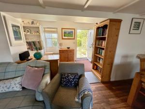 a living room with a couch and a chair at 14 Boscaswell Downs in Lower Boscaswell