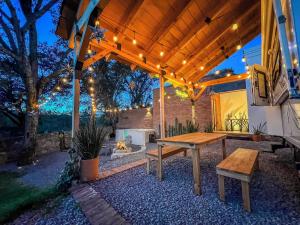a wooden pergola with a wooden table and benches at Glamping con Jacuzzi en Guanajuato in Santa Rosa de Lima +3 photos