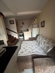 a living room with a bed and a staircase at Casa temporada SG in São Gabriel