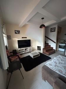 a living room with a bed and a tv at Casa temporada SG in São Gabriel