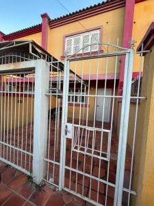 a metal fence in front of a house at Casa temporada SG in São Gabriel