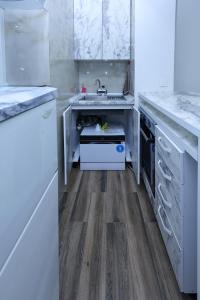 a white kitchen with a sink and a dishwasher at GAMA Apartments in Bitola
