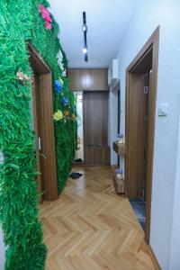 a hallway with a green wall with flowers at GAMA Apartments in Bitola +17 photos