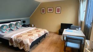 a bedroom with a bed and a table in it at De Drie Populieren in Losser