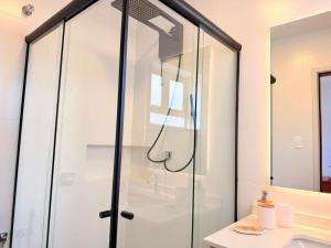 a glass shower in a bathroom with a sink at Apartamento Central em Araxá in Araxá +40 photos