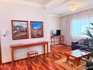 a living room with a table and a couch at Apartamento Central em Araxá in Araxá