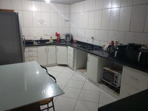 a kitchen with a sink and a stove top oven at casas praias familiar in Piçarras +25 photos