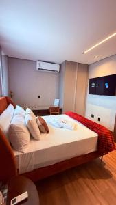 a bedroom with a bed with white sheets and pillows at Flat Vinhedo in Montes Claros