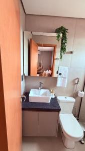 a bathroom with a sink and a toilet and a mirror at Flat Vinhedo in Montes Claros