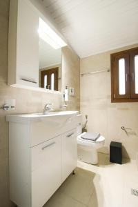 a white bathroom with a sink and a toilet at Raise Polydrosos Traditional Getaway in Polydrossos +39 photos