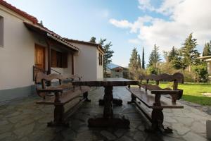 a group of wooden benches sitting outside of a building at Raise Polydrosos Traditional Getaway in Polydrossos