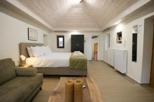 a bedroom with a bed and a couch and a table at Raise Polydrosos Traditional Getaway in Polydrossos
