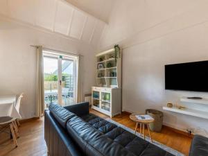 a living room with a couch and a flat screen tv at Nieuwendamme H114 in Lombardsijde