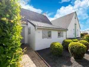 a white house with bushes in front of it at Nieuwendamme H114 in Lombardsijde
