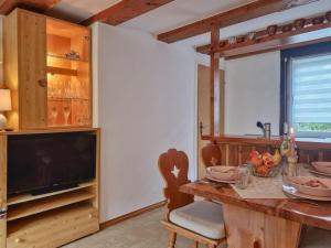 a dining room with a table and a television at Neubert in Breitenbrunn