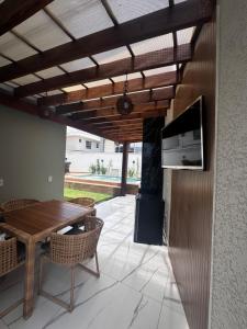 a patio with a wooden table and a stove at Casa Top in Porto Seguro