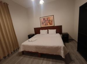 a bedroom with a bed with two shoes on it at La Cabaña Hostal in Mollendo