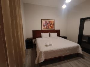 a bedroom with a bed with two shoes on it at La Cabaña Hostal in Mollendo