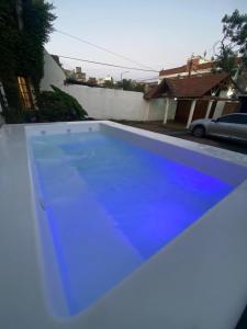 a blue swimming pool in a yard with a house at Why Not Guemes in Córdoba