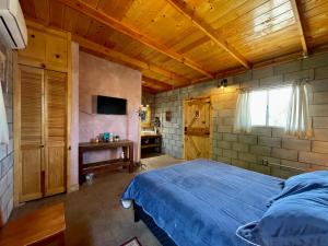 a bedroom with a blue bed and a wooden ceiling at Sn Tony Hotel & Spa in Valle de Guadalupe