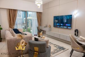 a living room with a couch and chairs and a tv at Central Park towers residence difc in Dubai
