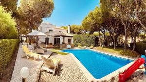 a swimming pool with a slide next to a house at Coreto's Village in Praia Verde