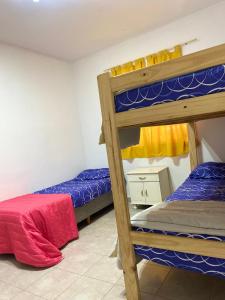 two bunk beds in a room with a red bed at Casa en la Punta San luis in La Punta